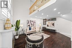 Vaulted ceilings, wood-finish flooring, built-in media console, upper cabinetry with glass fronts, and a natural wood railing - 