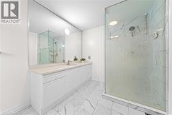 White vanity with dual integrated sinks, brushed nickel faucets, and a light-toned countertop - 
