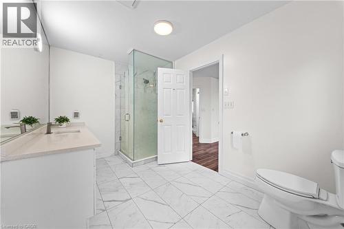 Bathroom featuring a glass-enclosed shower, white vanity with an undermount sink, light-toned countertop, and large format tile flooring - 495 Brigantine Drive, Waterloo, ON 
