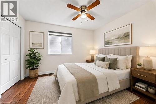 Wood-finish flooring, ceiling fan with integrated lighting, white bi-fold closet doors, and window with blinds - 495 Brigantine Drive, Waterloo, ON 
