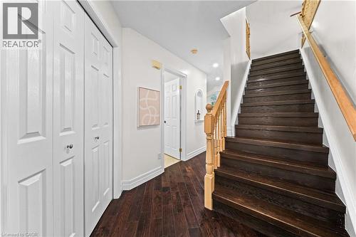 Wood-finish flooring, white paneled doors, dark wood staircase, wood handrail, recessed lighting - 495 Brigantine Drive, Waterloo, ON 