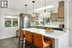 Kitchen with skylight and many updates: quartz counters, backsplash, appliances, lighting - 