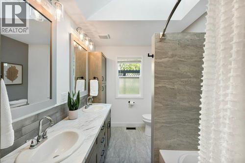 Main bath with dual vanities, tiled tub/shower surround - 886 Fairview Road, Oliver, BC 