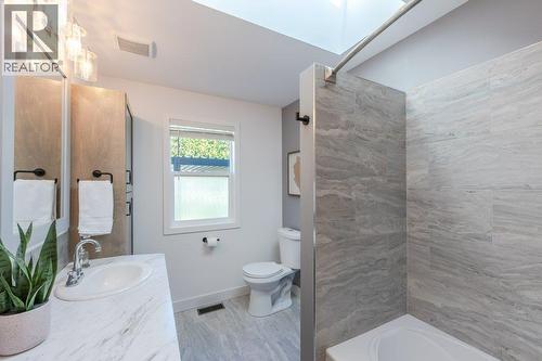 Main bath with dual vanities, tiled tub/shower surround - 886 Fairview Road, Oliver, BC 