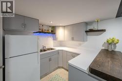 Kitchenette/wet bar with sink, fridge, cabinetry - 