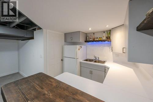 Kitchenette/wet bar with sink, fridge, cabinetry - 886 Fairview Road, Oliver, BC 