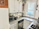 White cabinetry, stainless steel dishwasher, tile backsplash, and a single basin sink - 128 Kent Street S, Simcoe, ON 