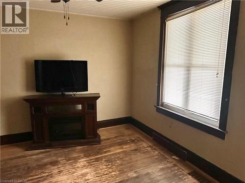 dark wood surround, window with white blinds, and a ceiling fan - 128 Kent Street S, Simcoe, ON 