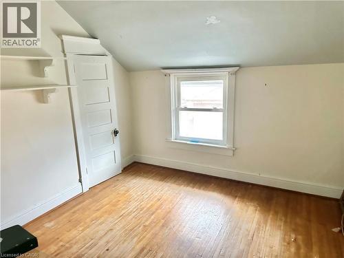 Bedroom , built-in shelving, white paneled door, and a single window with white trim - 128 Kent Street S, Simcoe, ON 
