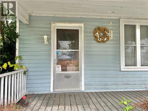 Exterior featuring horizontal siding, a covered porch with wood flooring, and a white screen door - 128 Kent Street S, Simcoe, ON 
