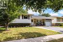 White siding exterior with brick accents, attached garage, paved driveway, and mature landscaping - 2037 Mountain Grove Avenue, Burlington, ON 