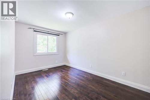 Rich wood-finish flooring, white walls, and a single window with white trim - 2037 Mountain Grove Avenue, Burlington, ON 