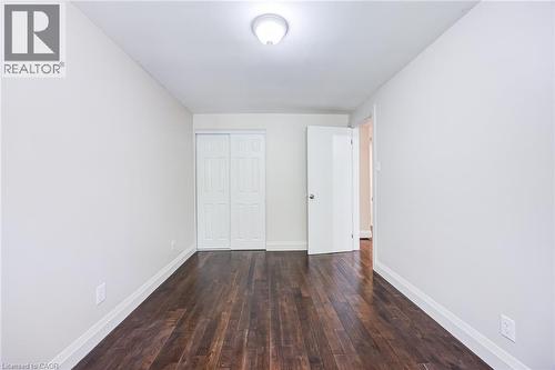 Dark wood-finish flooring, white walls, white trim, white bi-fold closet doors, and a ceiling-mounted light fixture - 2037 Mountain Grove Avenue, Burlington, ON 