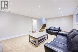 Recessed ceiling lighting, light-toned carpeting, a light gray wall color, white trim, and a window - 