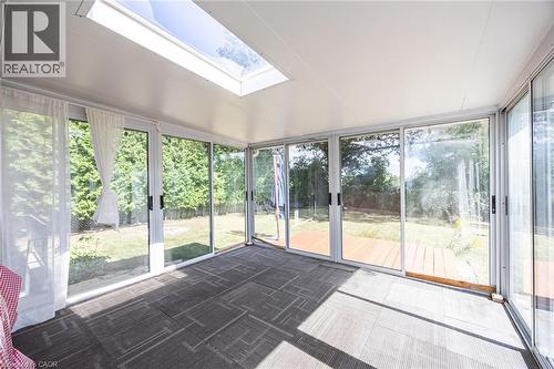 Sunroom with multiple sliding glass doors, a skylight, and patterned carpet flooring - 2037 Mountain Grove Avenue, Burlington, ON 