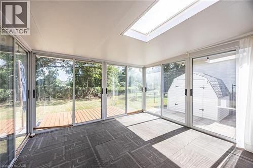 Sunroom with multiple sliding glass doors, a large skylight, and modular carpet flooring - 2037 Mountain Grove Avenue, Burlington, ON 