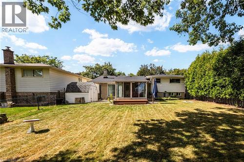 Expansive backyard with a wooden deck, mature perimeter trees, and a storage shed - 2037 Mountain Grove Avenue, Burlington, ON 
