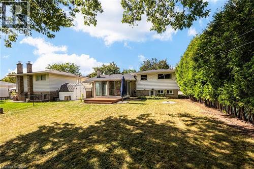Expansive backyard featuring a wood deck, mature trees, and privacy hedge - 2037 Mountain Grove Avenue, Burlington, ON 