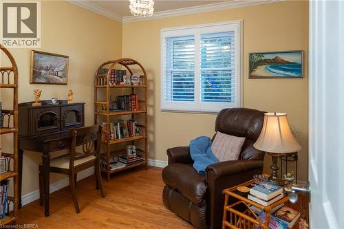 Wood-finish flooring, crown molding, and a built-in window with white plantation shutters - 78 Berkley Crescent, Simcoe, ON 