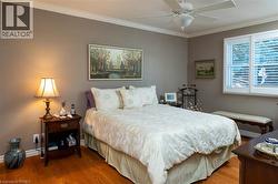 Hardwood flooring, crown molding, white window shutters, and a ceiling fan - 