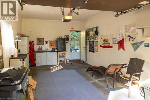Garage space with concrete flooring, overhead lighting, and an exterior door providing outdoor access - 78 Berkley Crescent, Simcoe, ON 