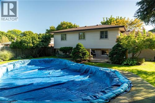 In-ground pool featuring a concrete surround, private wooden deck, and mature landscaping - 78 Berkley Crescent, Simcoe, ON 