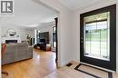 Entry door with decorative glass panels, crown molding, wood-finish flooring, white fireplace with mantel, and recessed lighting - 7 Shadywood Lane, Cambridge, ON 