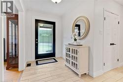 Entryway featuring a decorative transom door, light-toned tile flooring, and crisp white walls - 