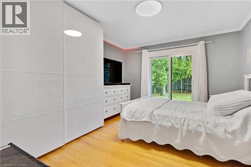 Hardwood-finish flooring, built-in wardrobe with panel doors, recessed ceiling lighting, sliding glass door, and crown molding - 7 Shadywood Lane, Cambridge, ON 