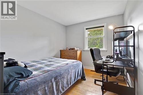 Hardwood-style flooring, white trim window, light gray wall finishes, and a built-in wood dresser - 7 Shadywood Lane, Cambridge, ON 