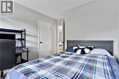 Light gray wall paint, white interior door with black hardware, wood-finish flooring - 7 Shadywood Lane, Cambridge, ON 