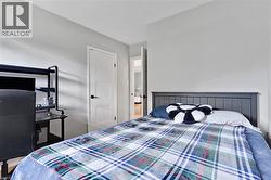 Light gray wall paint, white interior door with black hardware, wood-finish flooring - 