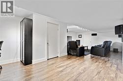Recessed lighting, wood-finish flooring, white walls, and a built-in display cabinet - 