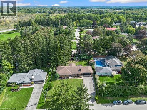 Aerial perspective showcasing multiple properties, an in-ground pool, and extensive surrounding greenery - 7 Shadywood Lane, Cambridge, ON 