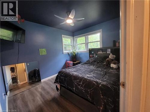 Wood-finish flooring, corner windows, ceiling fan with integrated lighting, and a built-in headboard storage unit - 33 Lee Avenue, Simcoe, ON 