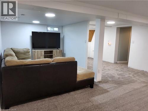Finished basement recreation area featuring recessed lighting, neutral carpeting, and a built-in media console with ample storage - 33 Lee Avenue, Simcoe, ON 