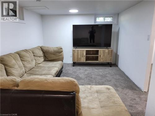 Recessed lighting, wall-mounted light switch, window with white trim, gray carpet flooring, white painted walls - 33 Lee Avenue, Simcoe, ON 
