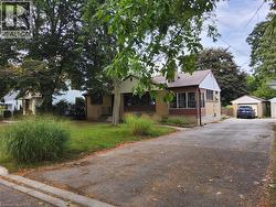 Single-story property featuring a metal roof, an enclosed front porch, and a brick exterior - 