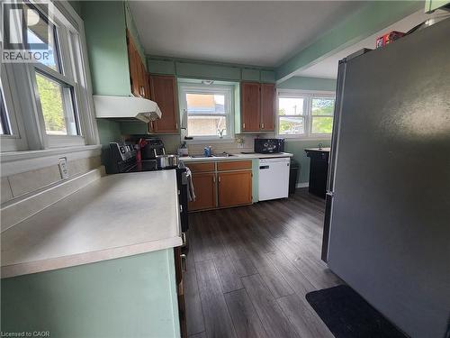 Wood-finish flooring, multiple windows, built-in cabinetry, and a range hood - 33 Lee Avenue, Simcoe, ON 