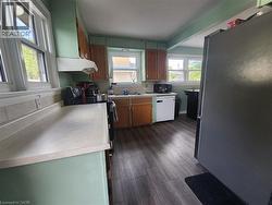 Wood-finish flooring, multiple windows, built-in cabinetry, and a range hood - 