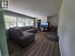Expansive windows with horizontal blinds, wood-finish flooring, and light-toned wall paint - 