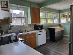 Recessed lighting, wood-finish flooring, multiple windows, built-in cabinetry, and a kitchen island with a wood-finish top - 