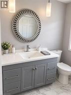 Vanity with gray cabinetry, white countertop, and an integrated rectangular sink - 