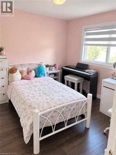 Room featuring wood-finish flooring, a window with window treatments, and a ceiling-mounted light fixture - 73 Larkspur Crescent, Kitchener, ON 