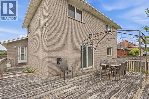 Brick exterior with multiple windows, a sliding glass door, and a permanent deck structure - 76 Madeira Crescent, Cambridge, ON 