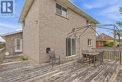 Brick exterior with multiple windows, a sliding glass door, and a permanent deck structure - 