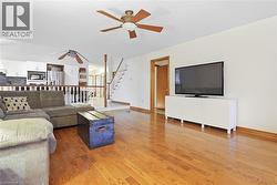 Hardwood flooring, white walls, and a ceiling fan with integrated lighting - 