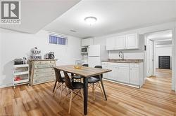 Full kitchen with white cabinetry, countertop, and a stainless steel sink - 