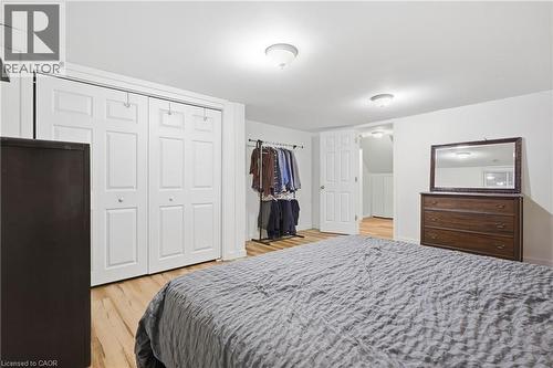 White walls, wood-finish flooring, flush mount lighting, and white bi-fold closet doors - 76 Madeira Crescent, Cambridge, ON 
