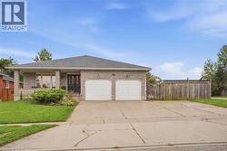 Stone veneer exterior with a covered front porch, double garage, asphalt shingle roof, and a concrete driveway - 